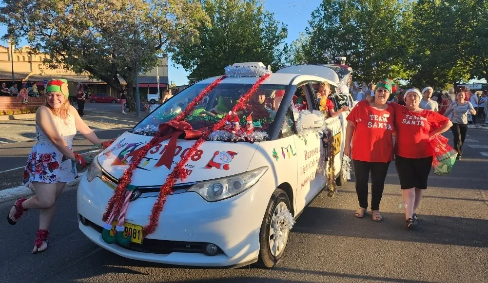 Team Santa walking with decorated Barossa & Light Cab Service vehicle